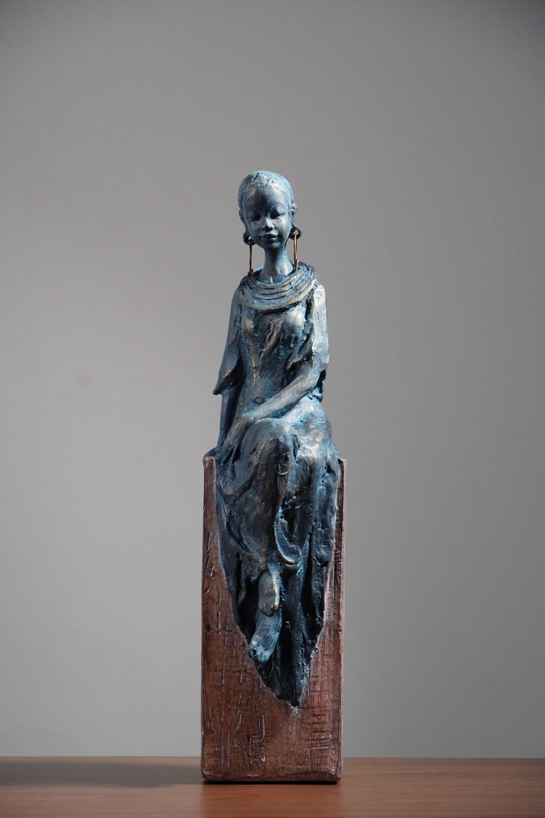 Seated Woman Sculpture on Wood Textured Pedestal – Forward-Facing Figure Statue