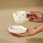 Cream Ceramic Cup with Multicolor Heart Embossed Design - The Golden Theory